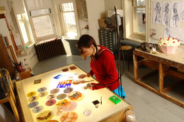 An image of artist Judith Schaechter in her studio producing work.
