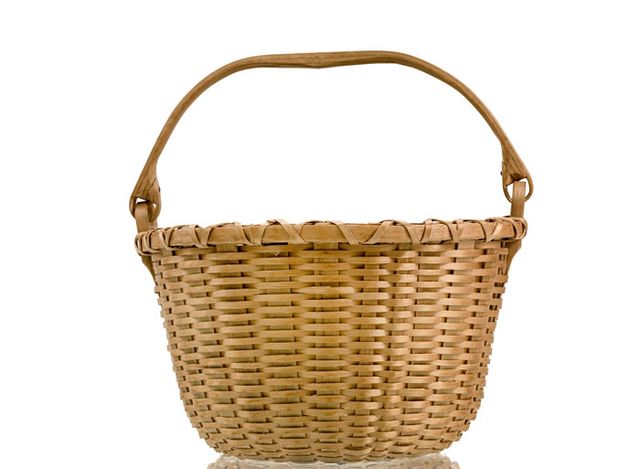 A small basket that's circular with a handle that goes across the body of the basket.
