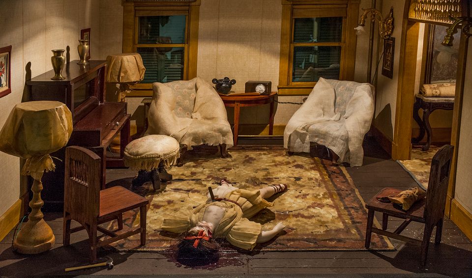 A photograph of a nutshell study of unexplained death showing a woman's death inside a parlor.