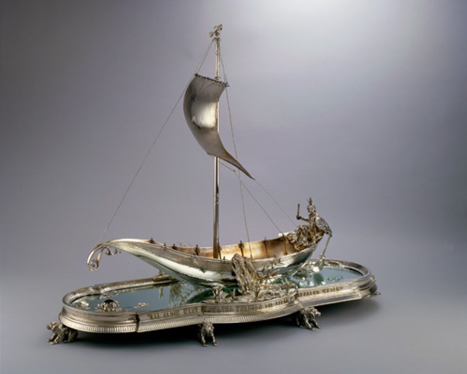 An image of a silver centerpiece that looks like a Hiawatha boat.