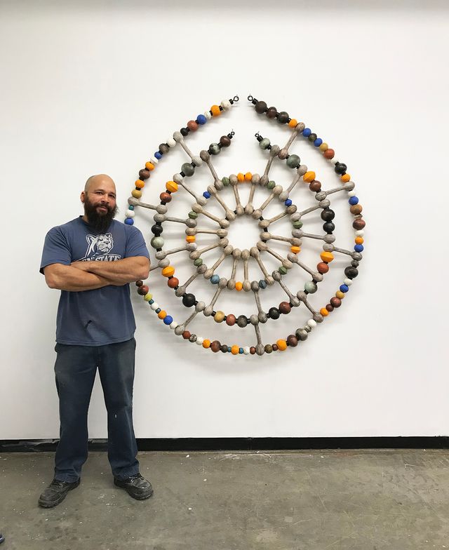 An image of a circular sculpture with small elements in different colors.