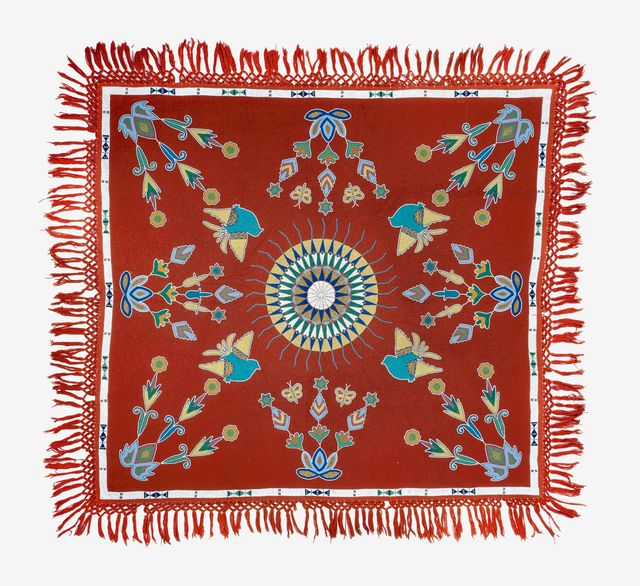 A red tablecloth with a circle in the middle and different designs around it.