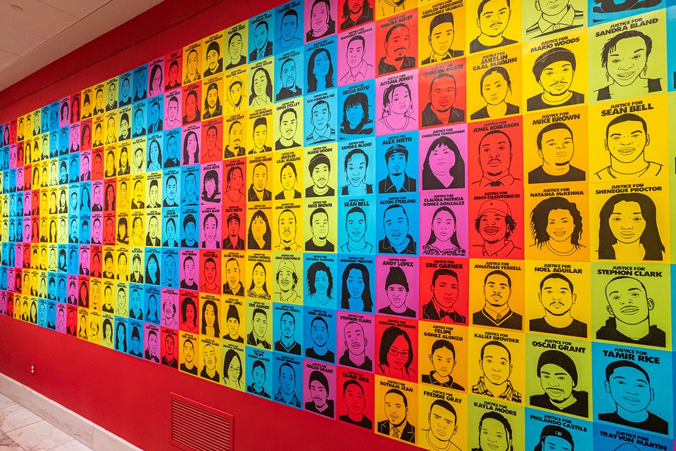 A photograph of a gallery wall with colorful artwork