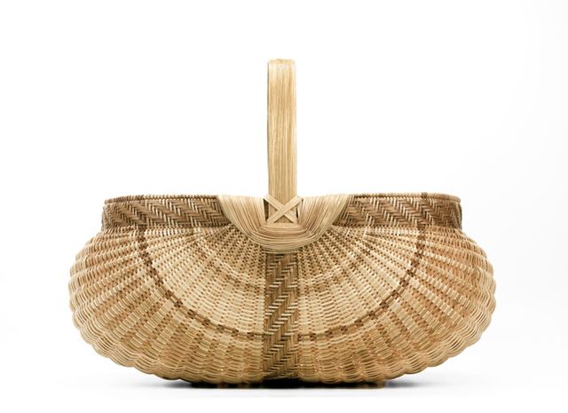 A basket with a half circle base and a handle across the middle.