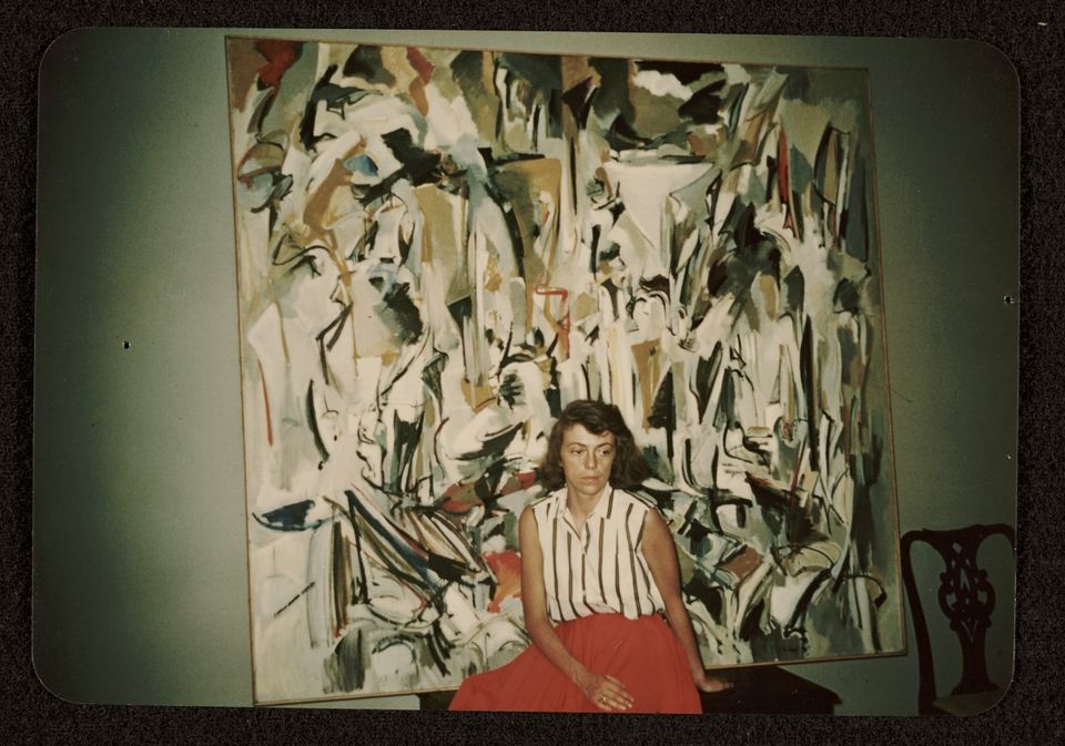 A photograph of artist Joan Mitchell with her painting Untitled (1951) 