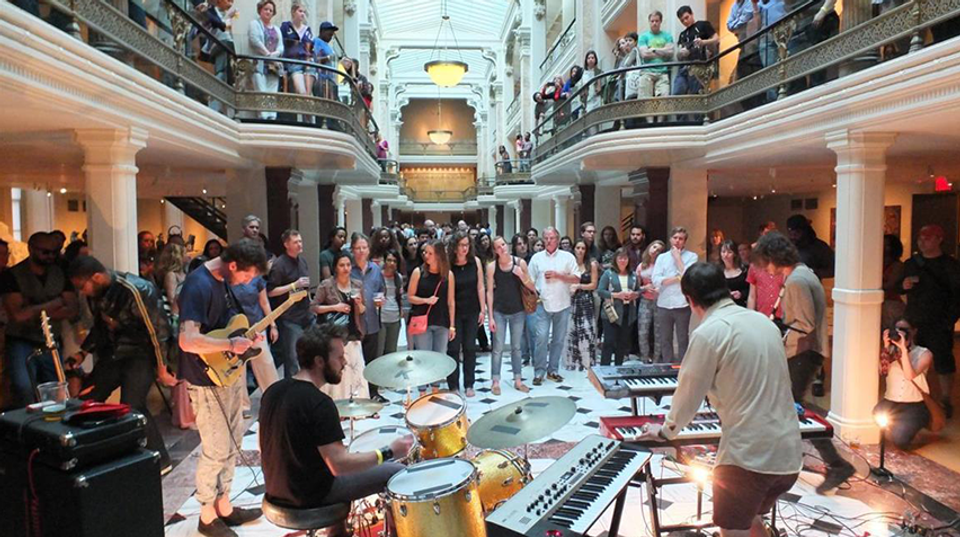 Photo of a band playing music in front of a crowd in the Luce Foundation Center