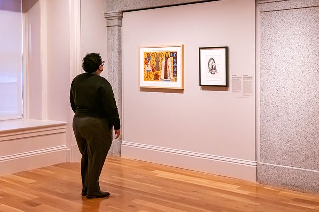 A photograph of a person looking at artwork