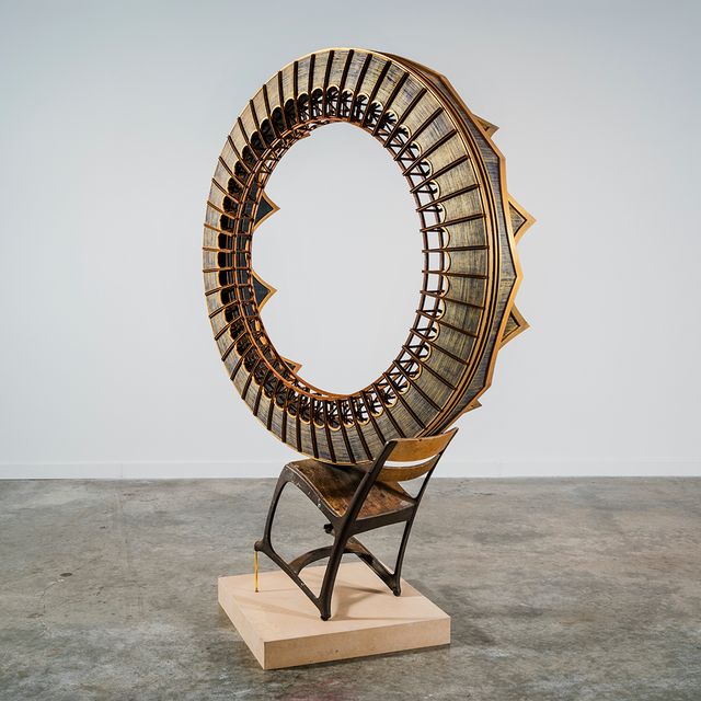 This is a picture of a circular sculpture piece resting on a chair.