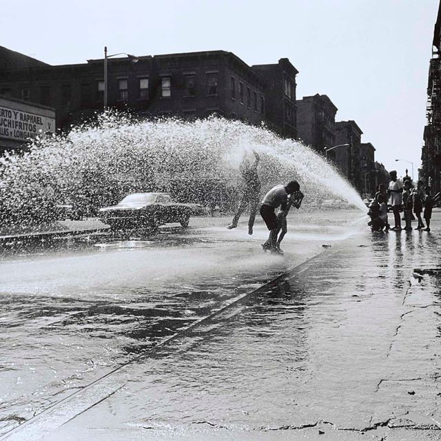 Photograph of children playing in the water from a fire hydrant by Hiram Maristany