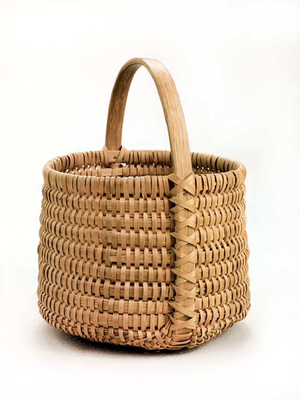 A basket that's small and deep with a circular shape and a handle.