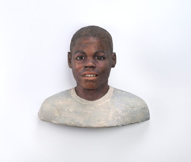 A sculpture of a young, black male with a short hair cut.