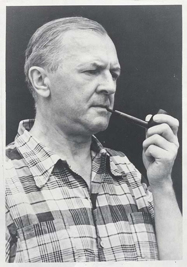 A photo of a man smoking a pipe. 