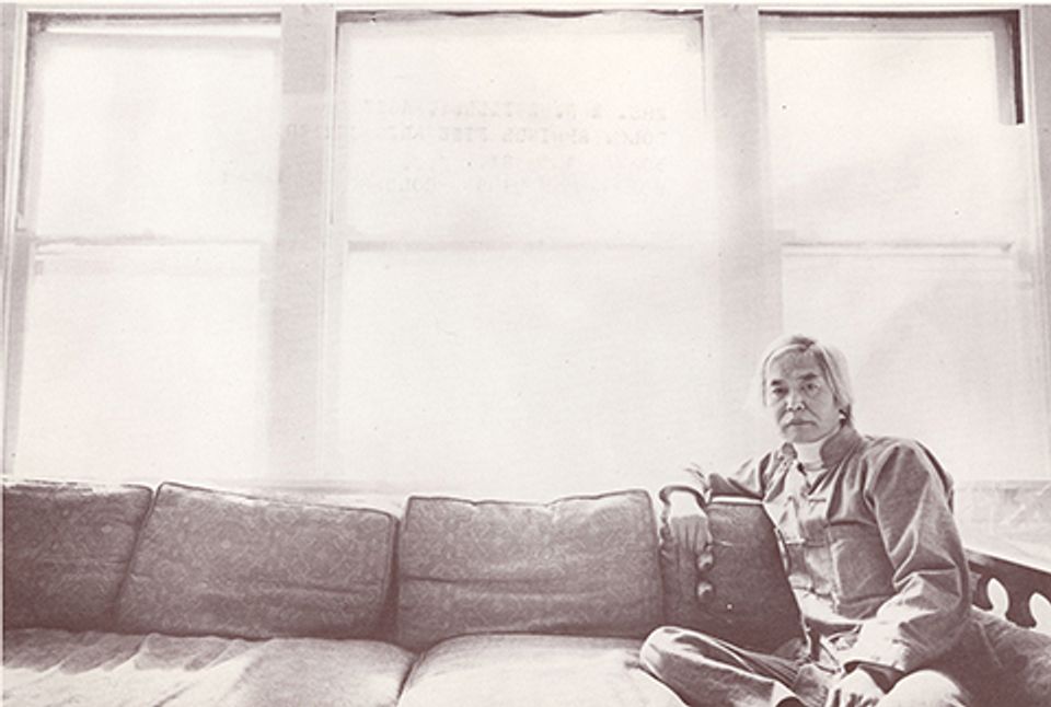 A photograph of a man sitting on a couch.