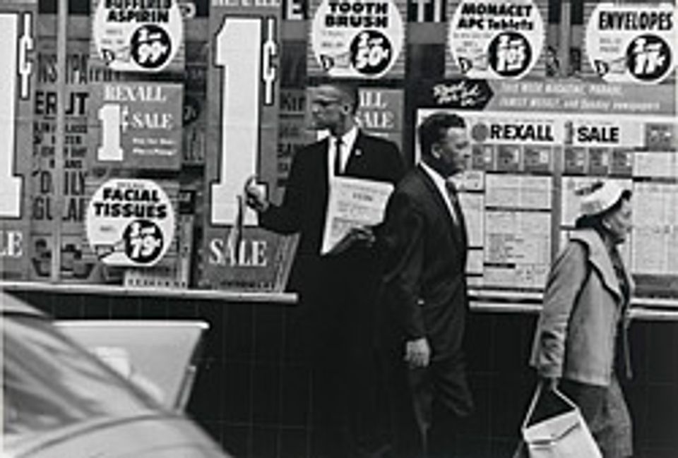 A photograph of Malcolm X on the street. 