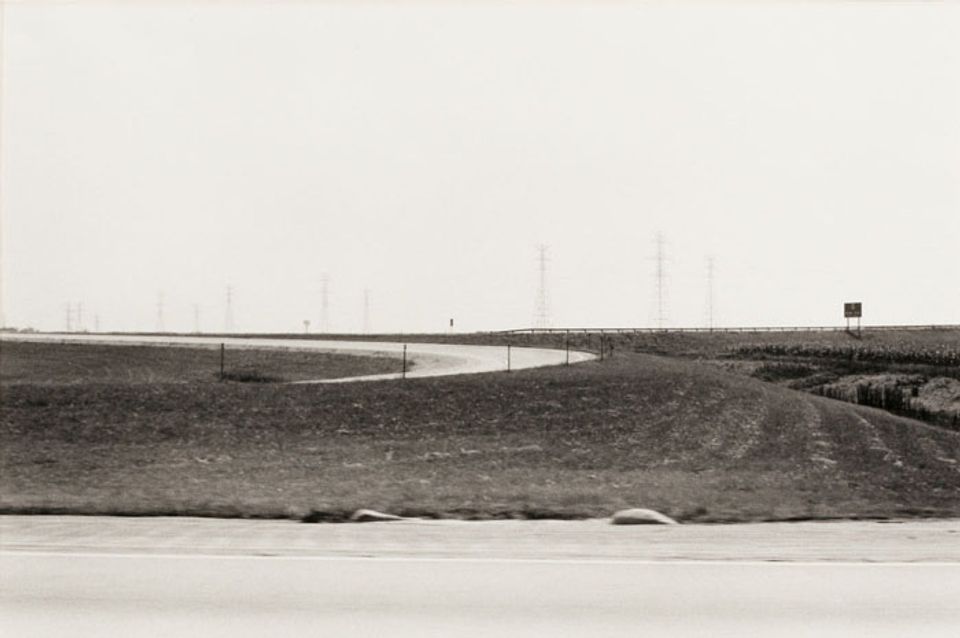A photograph of an Ohio landscape with a road taken by automobile.