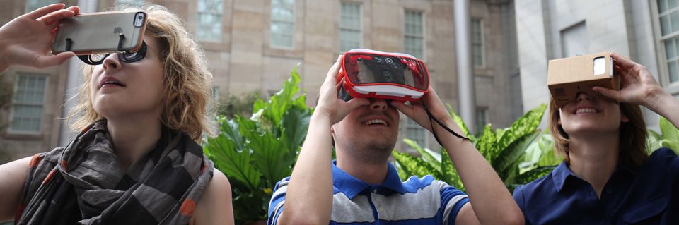 An image of three people playing the wonder360 app with different VR attachments to their smart phones. 