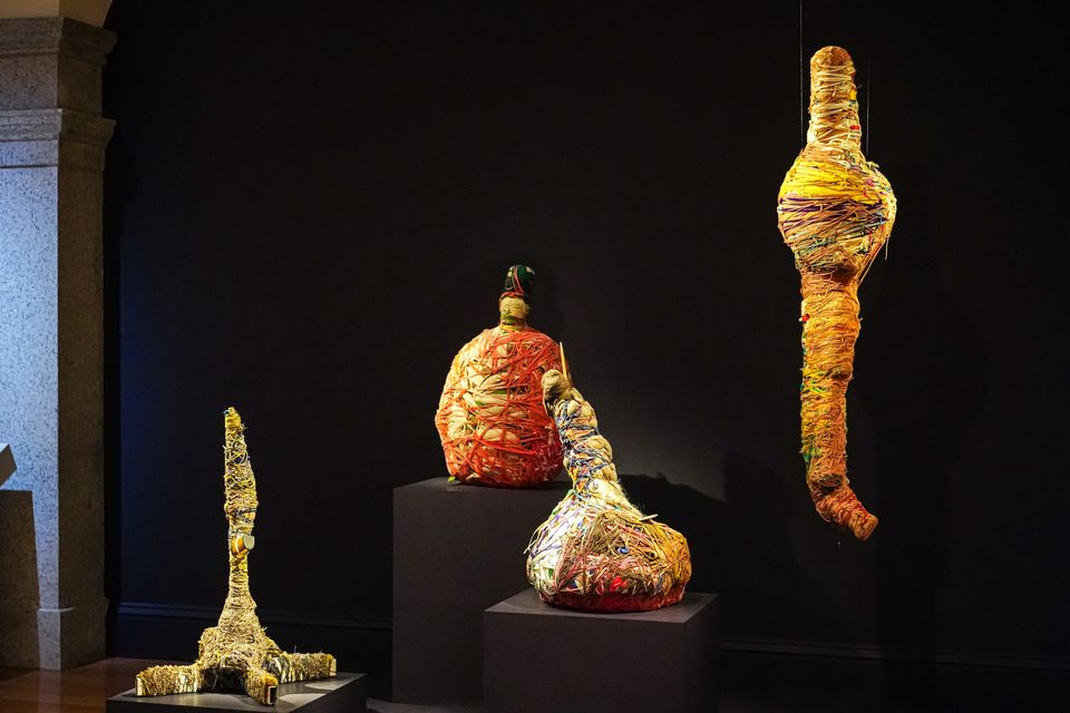 Exhibition gallery showing wrapped sculptures