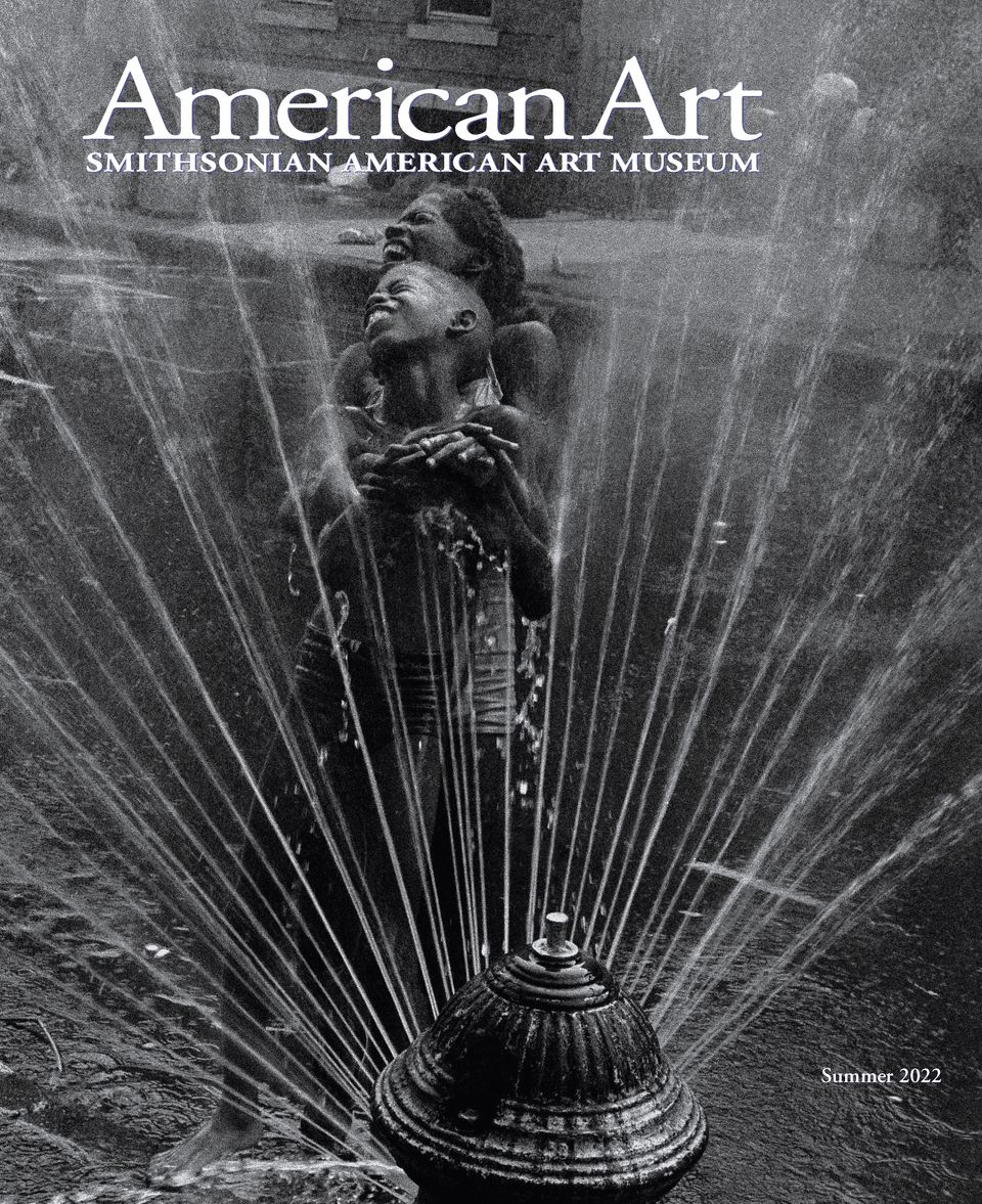 A black and white photograph of a mother and child being sprayed by water from a fire hydrant