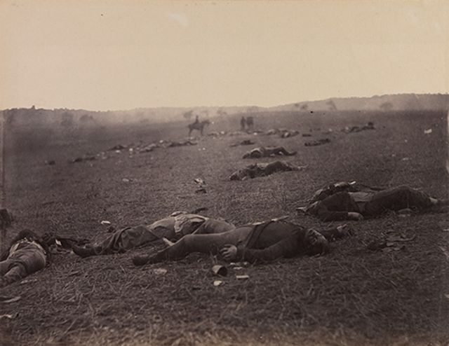 O'Sullivan's albumen print of a battlefield with dead soldiers scattered throughout.