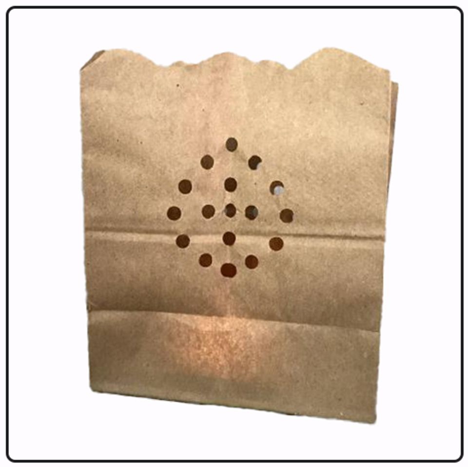 A brown paper bag cut decoratively to hold a candle.