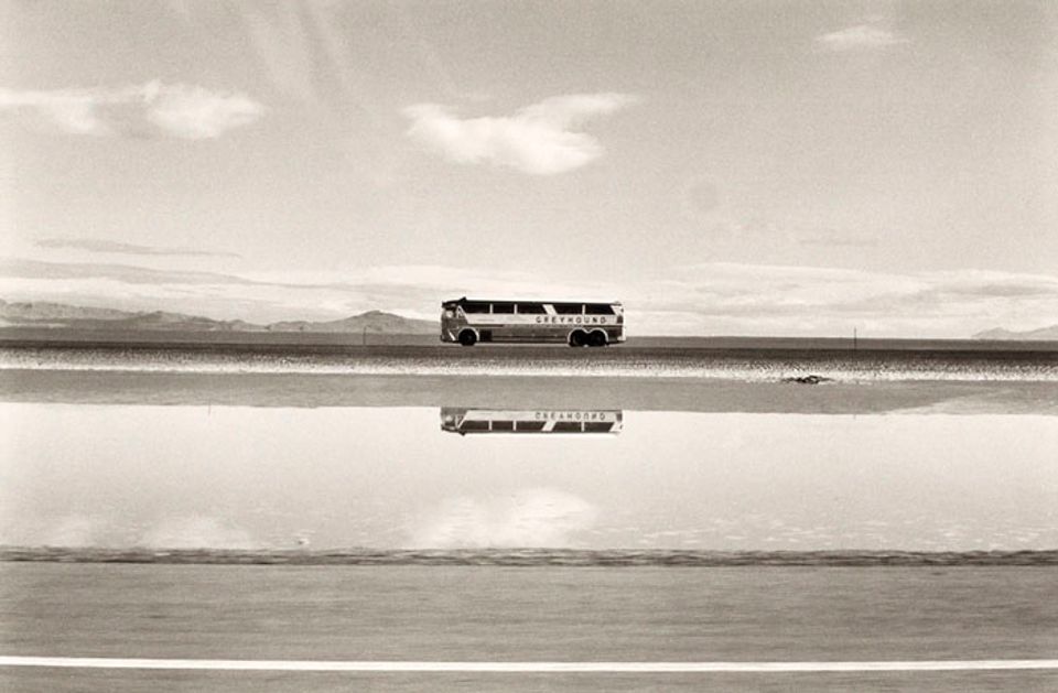 A photograph of a bus in a Utah landscape by automobile.