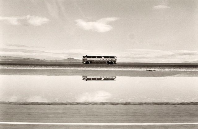 A photograph of a bus in a Utah landscape by automobile.