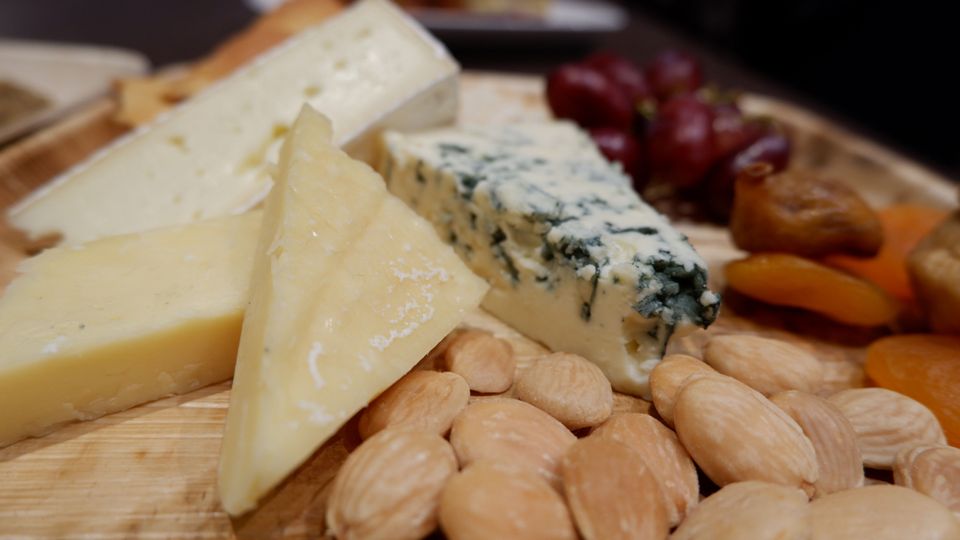 a cheese plate with almonds and olives