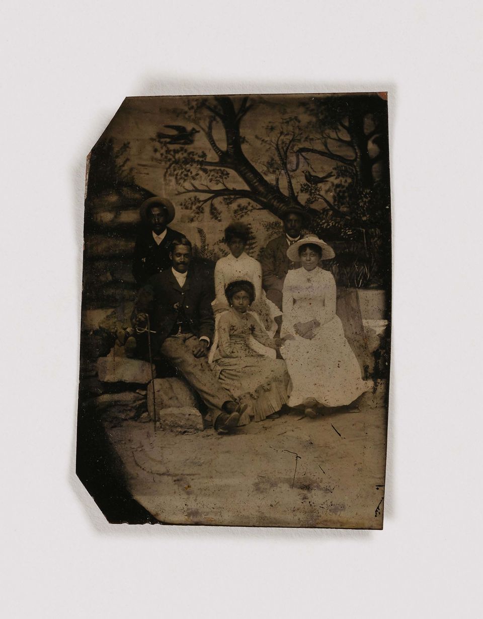 A tintype photograph of family standing in front of a tree 