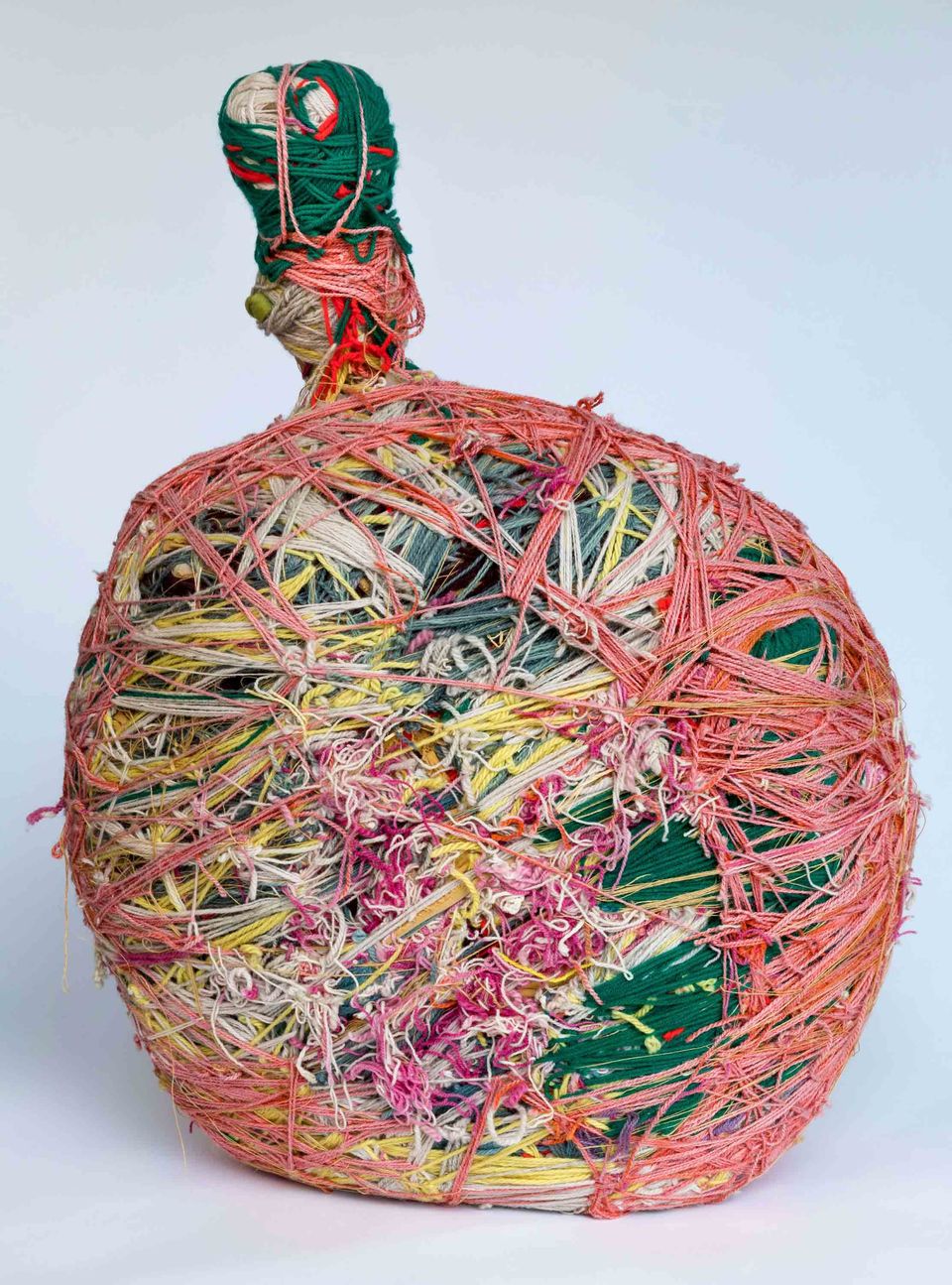 A sculpture in the shape of a bottle with wrapped pieces of string.